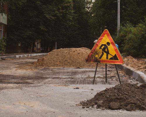 road works sign on the background of a road under construction